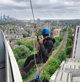 A rope access technician window cleaning in London