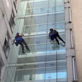 two abseilers cleaning glass 