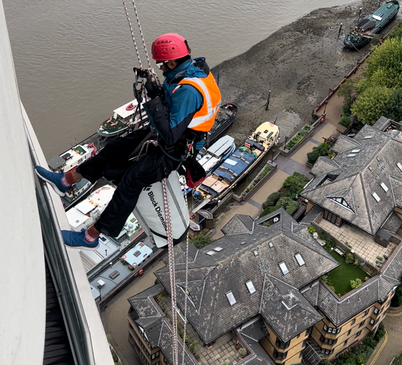 A team of experts performing maintenance work on a tall building, 